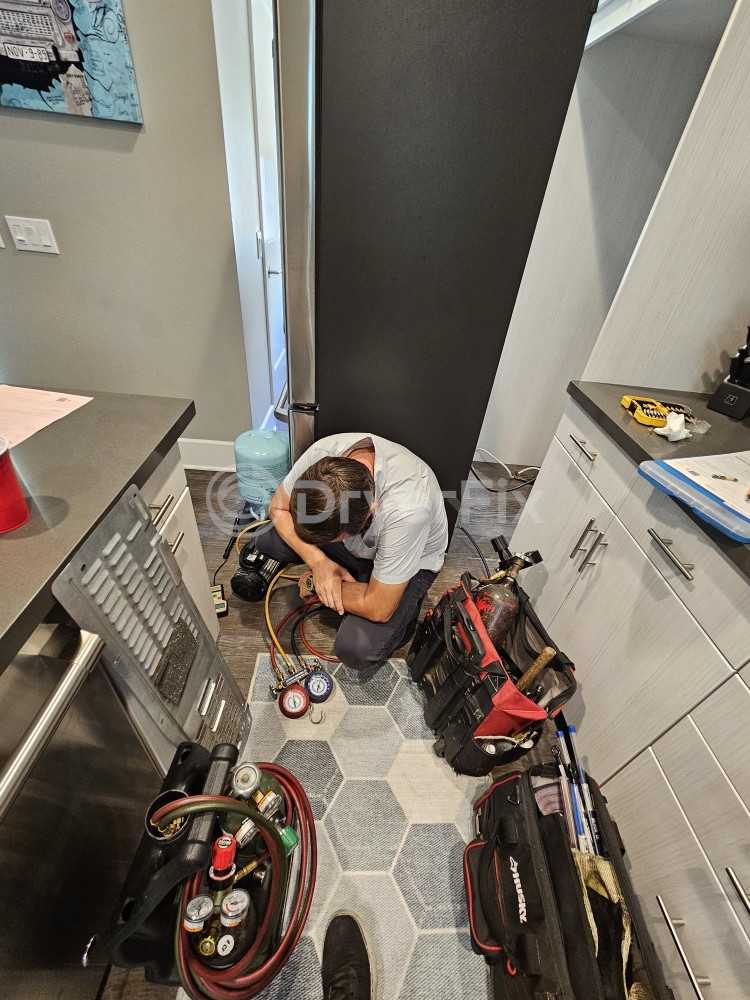 DryerFix technician servicing a stacked washer dryer unit